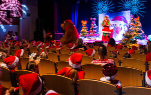 Na zdjęciu niedźwiadek oraz przedszkolaki na widowni