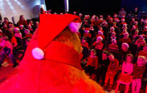 Na zdjęciu niedźwiadek oraz przedszkolaki na widowni