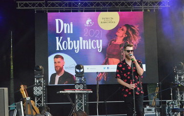 Na zdjęciu widać wokalistę na scenie podczas koncertu 