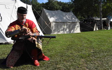 członek grupy rekonstrukcji historycznej ładujący muszkiet