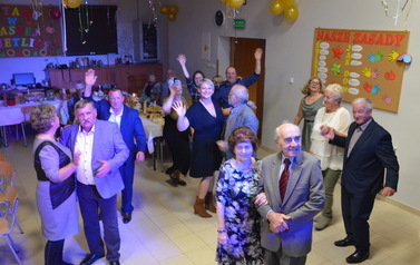 Grupa senior&oacute;w tańczy na sali balowej 