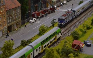 Na zdjęciu widać miniaturowe pociągi poruszające się na torach na makiecie  