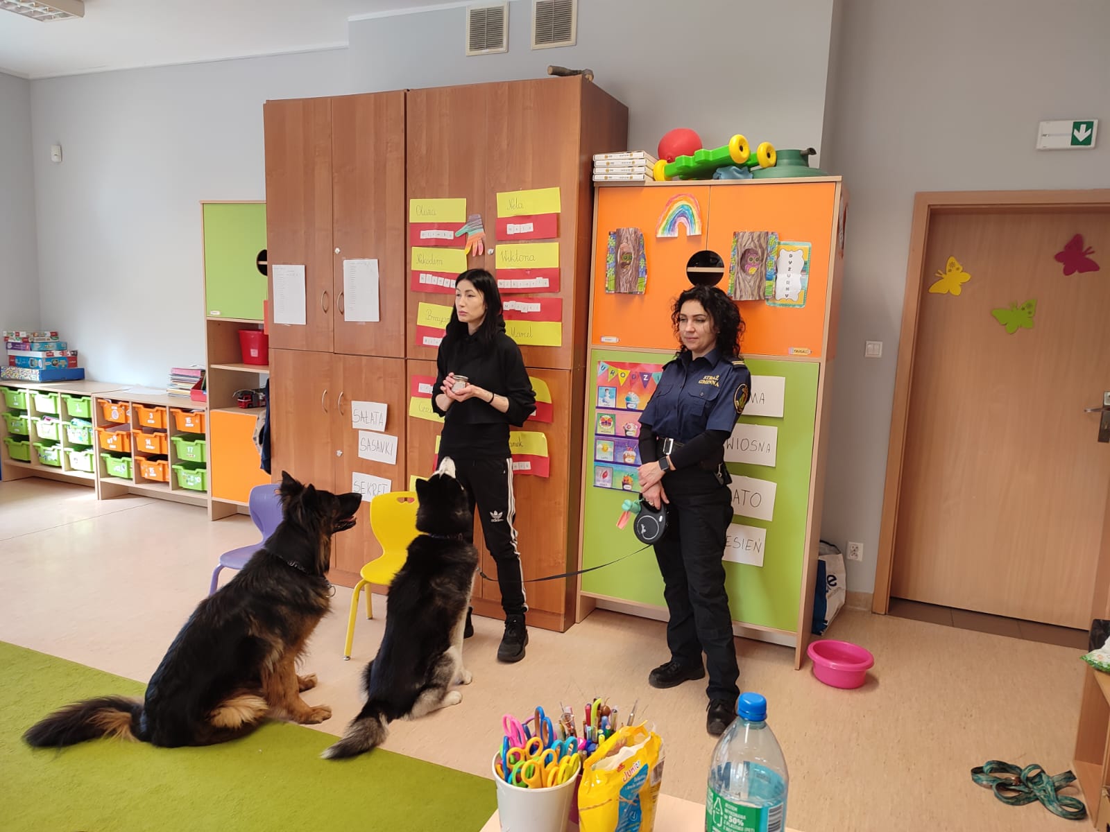 2 kobiety, 2 psy i&nbsp;dzieci słuchające prelekcji