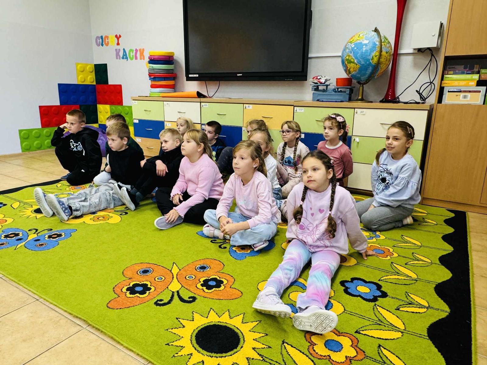 dzieci siedzą na&nbsp;podłodze i&nbsp;słuchają