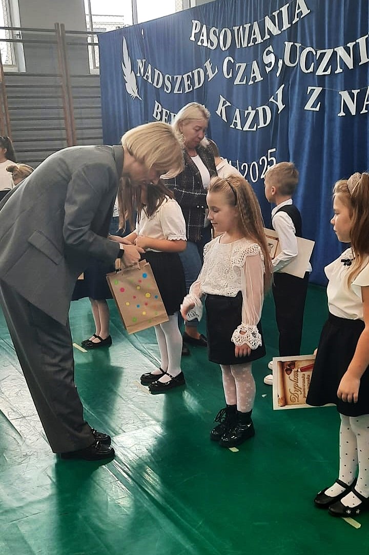 Na zdjęciu Zastępca Wójta Gminy Kobylnica Anna Gliniecka-Woś gratuluje pierwszakom.